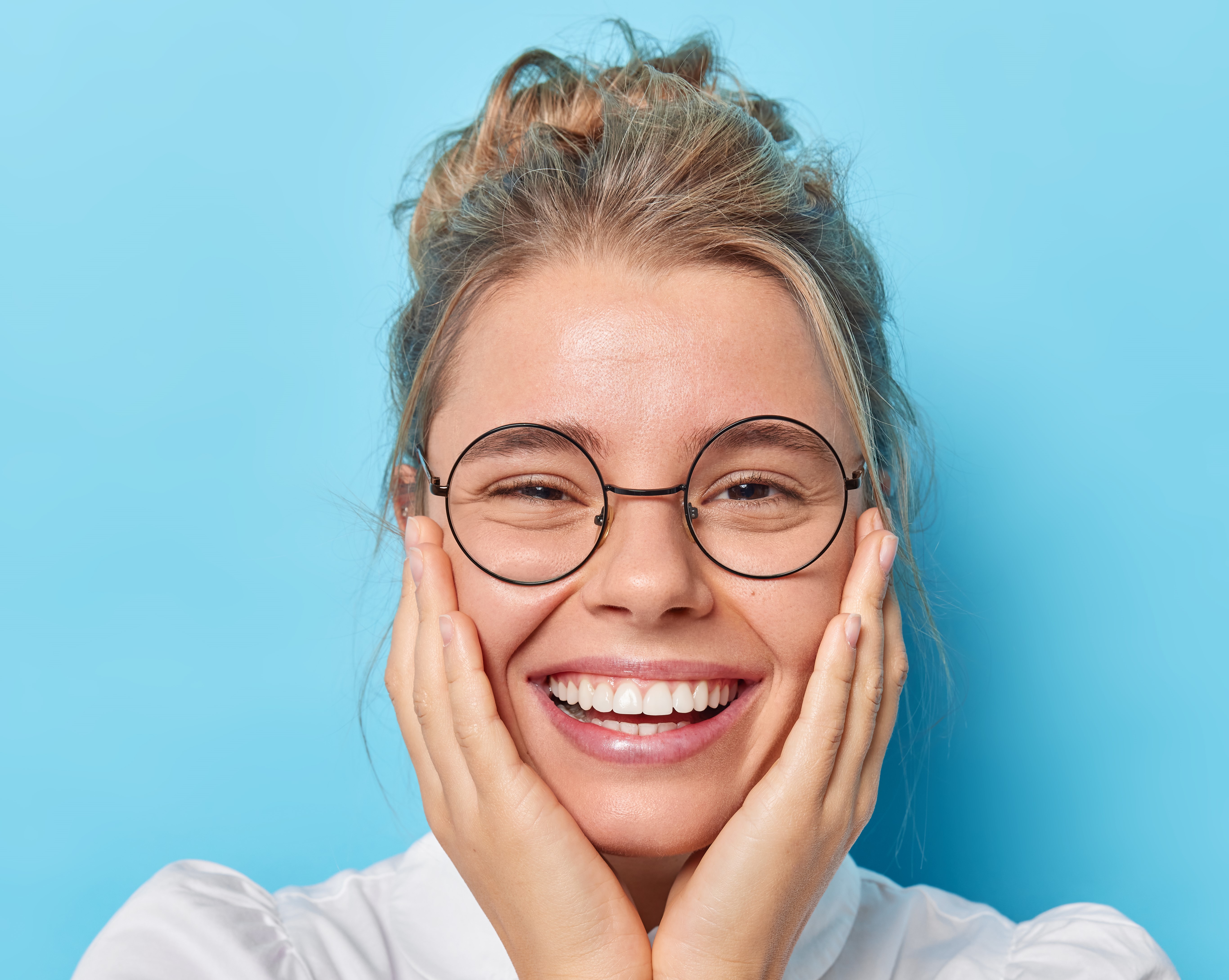 https://br.freepik.com/fotos-gratis/mulher-bonita-e-bonita-europeia-mantem-ambas-as-maos-no-rosto-sorrisos-amplamente-vestida-com-camisa-branca-oculos-transparentes-ouve-noticias-agradaveis-sobre-um-fundo-azul-parece-fofa-para-a-camera_21702768.htm#query=lentes%20dentarias&position=2&from_view=search&track=ais